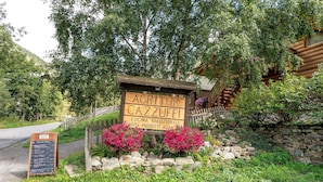Un cartello di legno rustico con la scritta 'AGRITUR Cazzuffi' e 'CUCINA TRADIZIONALE', che indica un ristorante di cucina tradizionale.
