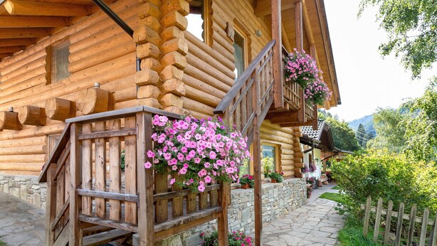 A wooden log cabin with a stone staircase leading to a wooden deck. - 'Primula' Room with Mountain View, Shared Garden and Wi-Fi (Cogolo di Peio)