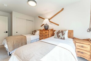 A bedroom with two beds, wooden furniture, a lamp, and a ceiling fan. - Oak at Outrun, brand new remodel, fireplace! (Mt. Crested Butte)