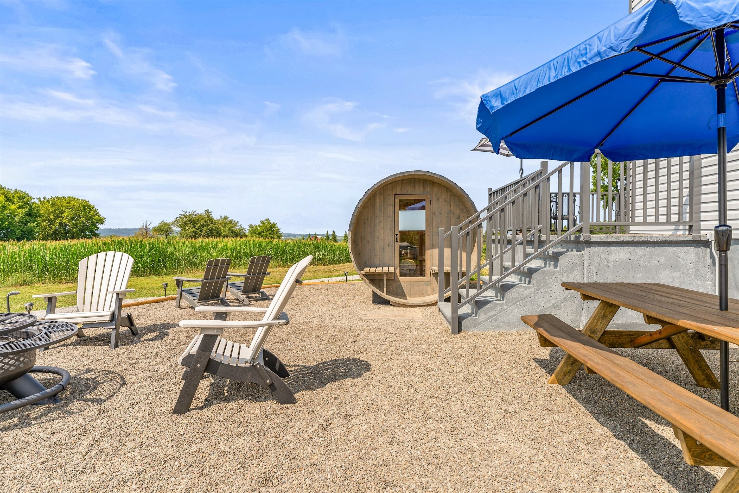 Cozy Adirondack chairs, picnic table, fire pit and a unique barrel sauna create the ultimate outdoor retreat.