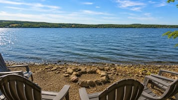 Une vue sur le lac, avec un foyer et des fauteuils Adirondack.