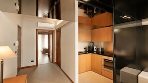 A modern kitchen with wooden cabinets, a black countertop, and a stainless steel refrigerator. - Cordigero - Riverside Suite (Peschiera del Garda)