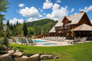 A lodge with a pool, lounge chairs, and a mountainous backdrop. - BOREA Chalet | Spa, Golf & Outdoor Activities (Mont-Blanc)