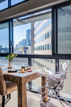 A modern office space with a large window overlooking a cityscape. - Heritage Top Floor Loft CBD Parking (Melbourne)