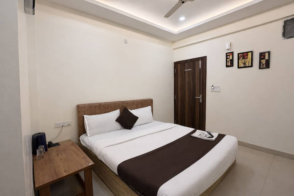A neatly arranged bedroom with a bed, bedside table, and a wardrobe.
