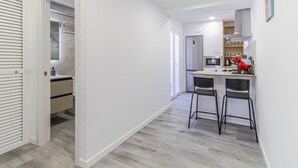A modern kitchen with a refrigerator, microwave, and red appliances. There are two black chairs and a countertop with a sink. - Marbella 22 Beach&Comfort just steps from the sea (Marbella)