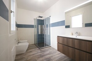 Een douche, een haardroger, een bidet, handdoeken