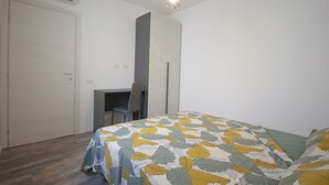 A bedroom with a bed, a desk, and a chair. - Sant'Avendrace: Spacious Apt. 3 bedrooms, 2 baths (Cagliari)