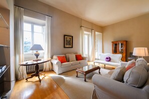 Un salon comprenant un canapé, une table basse, une lampe et un meuble.