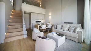 Una sala de estar moderna con una escalera, un comedor y una cocina.
