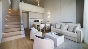Una sala de estar moderna con un sofá, una mesa de centro y un comedor con sillas.