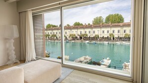 Una habitación con un ventanal grande que da a un puerto deportivo con barcos y edificios.