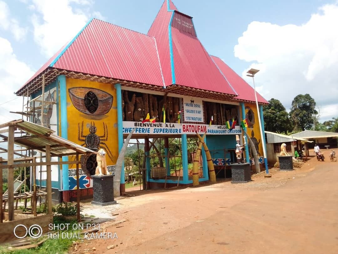 A colorful building with a red roof and a sign welcoming visitors.