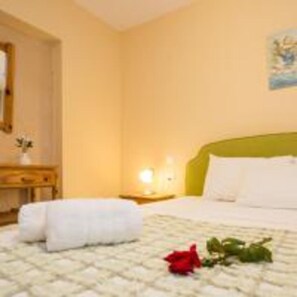A hotel room with a bed, a nightstand, and a wall-mounted lamp. - Limonero New City Apartment 1 With Private Parking (Lefkada)