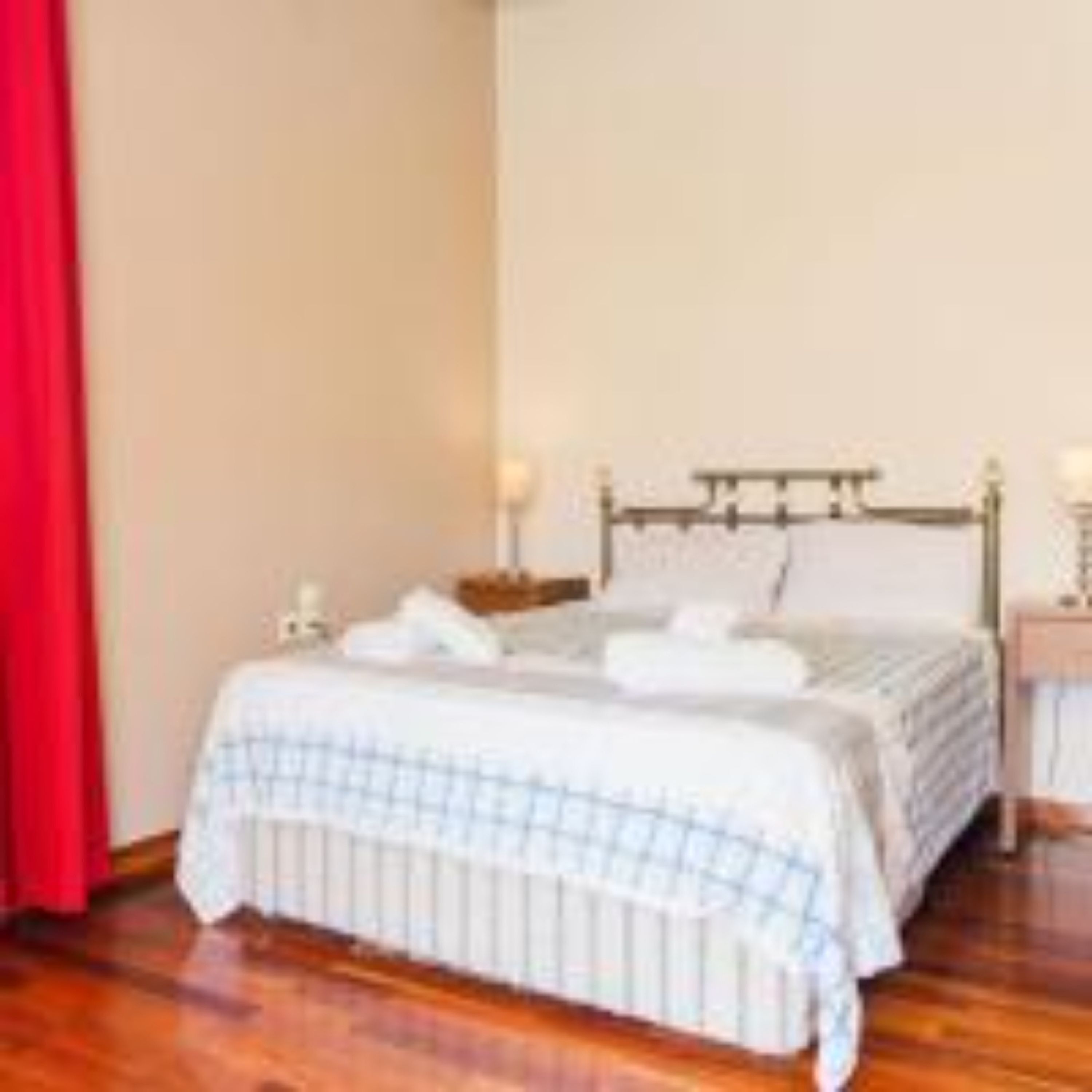 Un dormitorio con cama, mesitas de noche y una mesilla.