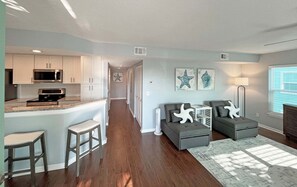 A modern living space with a kitchen, seating area, and artwork.