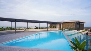 A rooftop swimming pool with a glass balustrade, a covered seating area, and a view of the ocean. - One bedroom Luxury @ Loxwood…..Enjoy! (Accra)