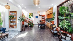 A spacious lobby with a staircase, a dining area, and a reception desk. - AuLac Hoian Homestay (Hoi An)
