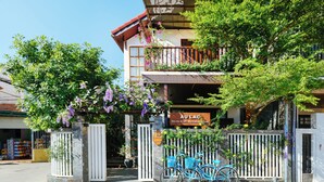 A building with a sign reading 'AU LAC Hot An Craft Workshop House' and a gated entrance with bicycles parked in front. - AuLac Hoian Homestay (Hoi An)