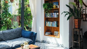 A modern living room with a large window, a bookshelf, a sofa, and a coffee table. - AuLac Hoian Homestay (Hoi An)