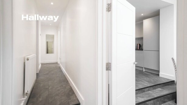 A modern hallway with a white door leading to a kitchen area. - Modern 3 Bed room Apartment with 4 Beds and 2 Full Bathrooms - Sleeps 6 (London)