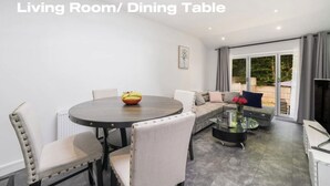 A living room with a dining table, chairs, a sofa, and a coffee table. - Modern 3 Bed room Apartment with 4 Beds and 2 Full Bathrooms - Sleeps 6 (London)