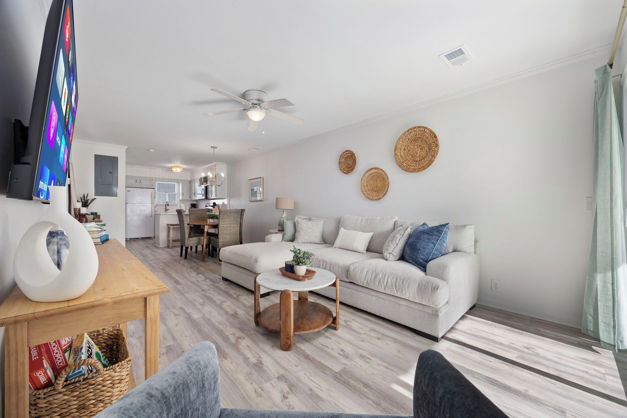 A modern living room with a sofa, a coffee table, and a TV on a stand.