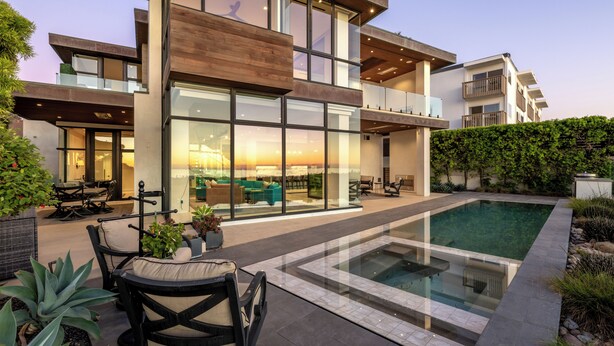 A modern multi-story house with a large glass facade, outdoor seating area, and a swimming pool. - Luxury Coastal Escape w/ Resort-Style Amenities & Stunning Views (Del Mar)