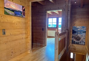A wooden interior with a view to the outside, a radiator, and a door leading to another room. - Quiet "Weideblick" Vacation Apartment in the Heart of Nature in Schluchsee-Blasiwald (Schluchsee)