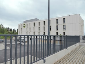 Ein modernes Gebäude mit flacher Fassade und zahlreichen Fenstern.