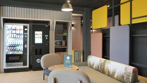 A modern seating area with a vending machine, a microwave, and a sign encouraging deep breathing. - BB HOTEL Carcassonne Rocadest La Cite (Carcassonne)