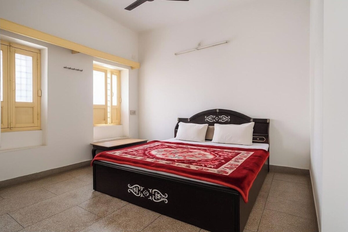 Une chambre à coucher avec un lit, une fenêtre et un ventilateur de plafond.
