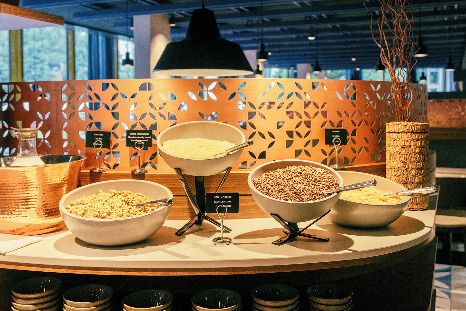A buffet area with various food items including rice, cereal, and beans.