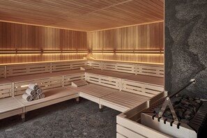 A sauna with wooden benches and a stone wall. - The View (St. Moritz)