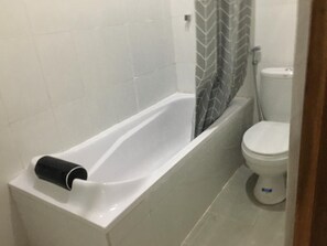 Ein Badezimmer mit einer weißen Badewanne, einer Toilette und einer Duschvorhang.
