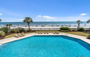 A swimming pool with a view of the beach and ocean.