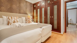 Ein Hotelzimmer mit einem großen Bett, einem Holzschrank und einer Wand mit Muster.