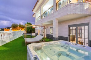 Un hôtel moderne doté d’un bain à remous, d’un espace extérieur aménagé et d’une pelouse bien entretenue.