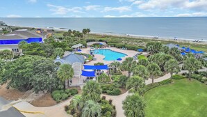 A resort with a large pool, palm trees, and a view of the ocean. - Oceans Rest Private Pool, luxury living in DeBordieu 7 bedrooms (Georgetown)