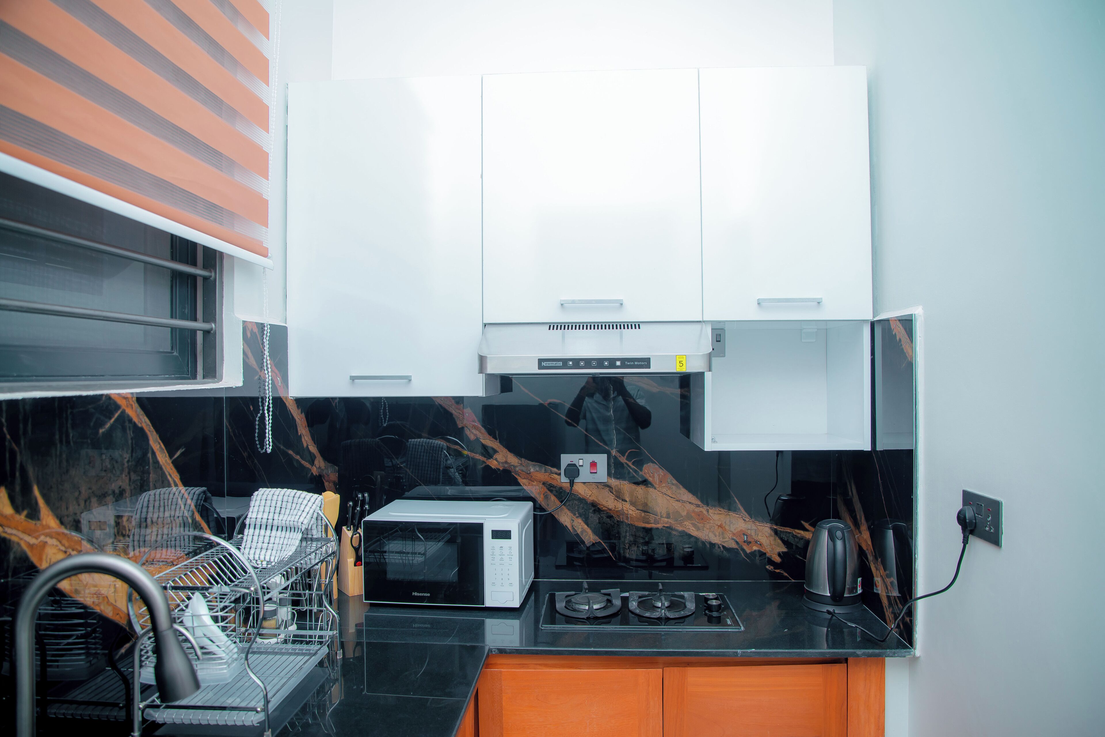 Cocina compacta con microondas, estufa y muebles de cocina modernos.