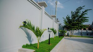 A modern building with a clean, white facade, a well-maintained lawn, and a paved walkway. - Staycation Villas (Dodoma)