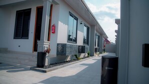 A modern building with large windows, a fire extinguisher, and a trash bin. - Staycation Villas (Dodoma)