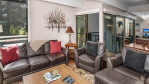 A modern living room with leather sofas, a coffee table, and a decorative wall piece. - Pool, Hot Tub, Walk to Gondola | VI111 (Vail)