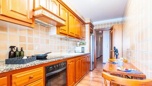 Una cocina con armarios de madera, microondas y una mesa de comedor con sillas.