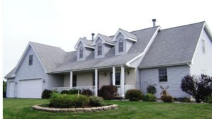 A two-story house with a gabled roof, a front porch, and a garage. - 3BR Retreat in a House 2Floor (Yorkville)