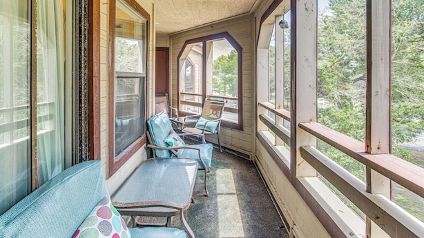 A covered porch with wooden railings, a bench, and two tables with chairs. - < 1/2 Mi to the Sand! Myrtle Beach Family Condo (Myrtle Beach)