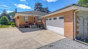 Ein zweistöckiges Haus mit Garage, überdachter Terrasse und kleinem Vorgarten.