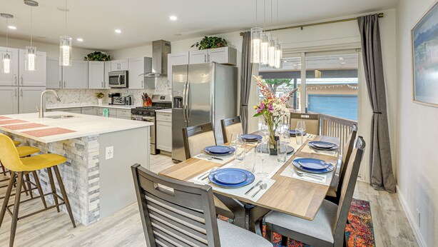 A modern kitchen with a central island, stainless steel appliances, and pendant lighting.