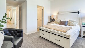 A bedroom with a bed, bedside tables, a chair, and a plant. - Home w/ Private Patio 10 Mi to Rio Grande! (Las Cruces)