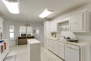 A spacious kitchen with white cabinetry, a built-in microwave, and a dishwasher.